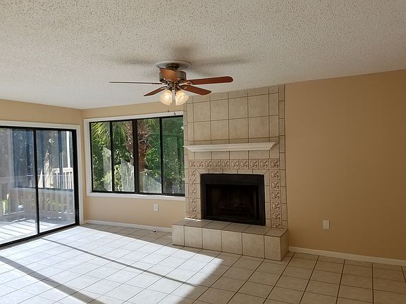 Living room with large windows, balcony and fireplace.