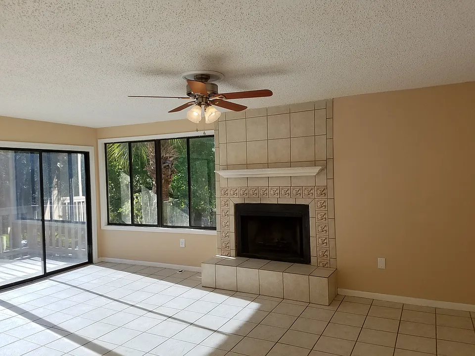 Living room with large windows, balcony and fireplace.