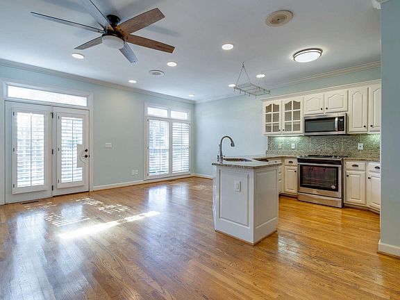 Kitchen with new appliances, eating bar and casual gathering area. Full length windows and atrium door to back patio shed cheerful light!