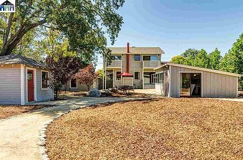 A BBQ area with seating conveniently located in backyard.