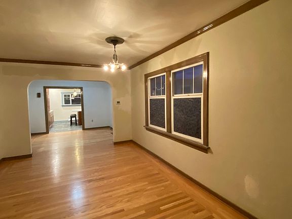 living room with newly refinished oak wood floors. (walls are in the process of being painted a more neutral off white.) Vintage chandelier is original to this 1918 home, as well as the crown molding and stained woodwork. updated photos coming very soon.
