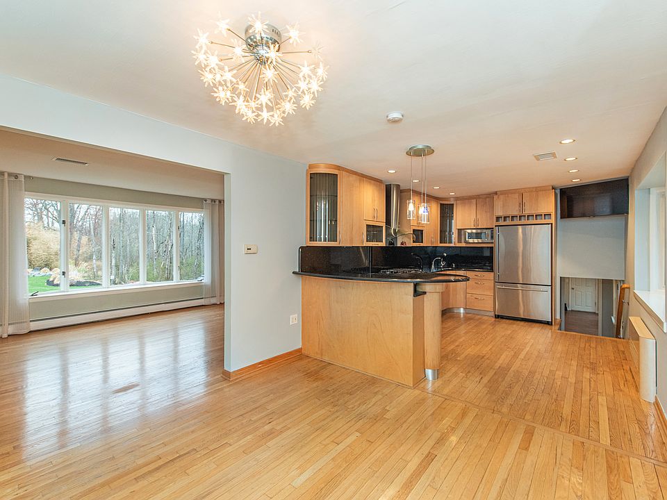 Open kitchen/dining area w/ stainless appliances & hardwood floors