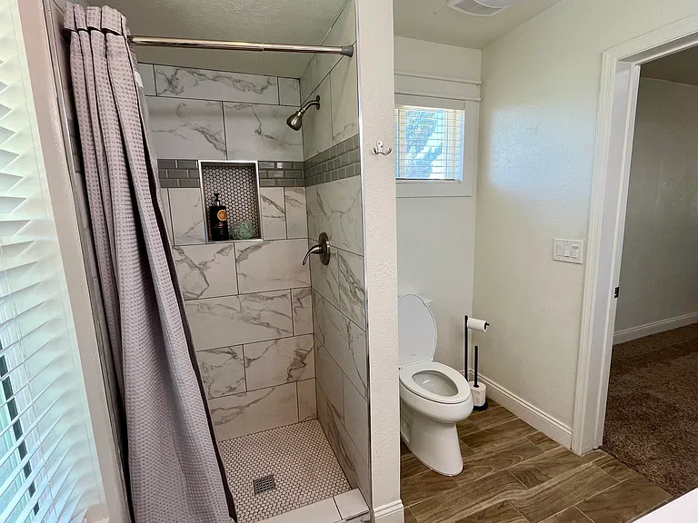Master bathroom with new walk in shower and new kohler toilet. New fans, windows and blinds.