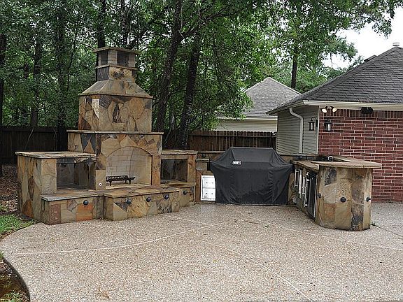 Outdoor living at it's best! Gorgeous stone outdoor fireplace and outdoor kitchen. BBQ, refrigerator