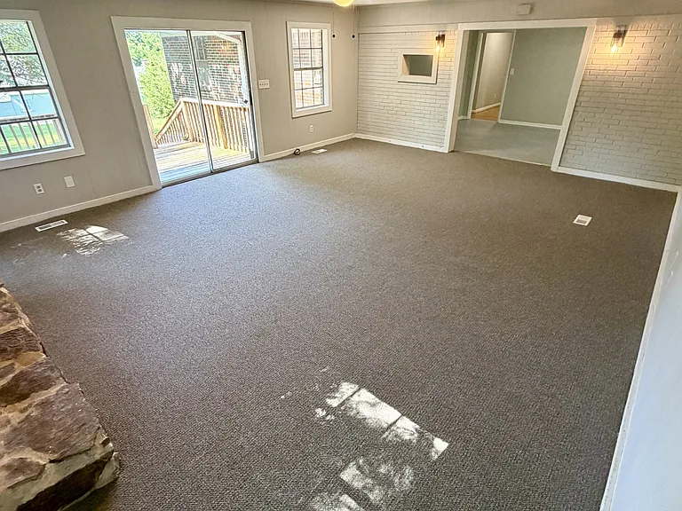Living room with door to back porch, view looks toward the kitchen