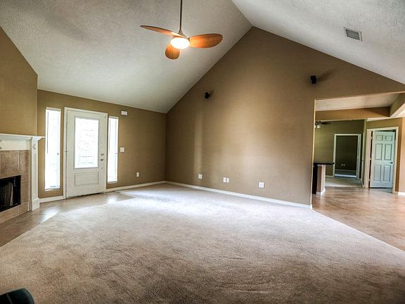 Family room has soaring cathedral ceilings and fireplace with tile surround and wood mantle. Opens u