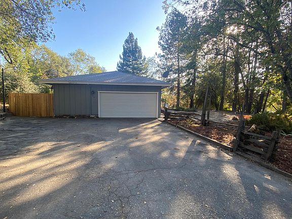 Spacious 2-car garage door with extra storage area. Garage is large with a work bench and cabinets.