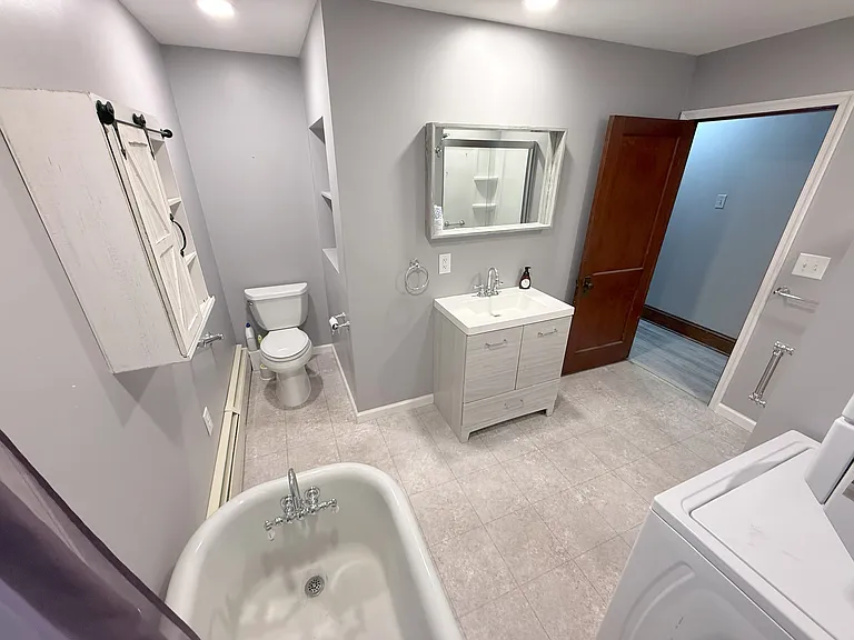 Bathroom with walk in shower and soak tub. Washer and dryer combo unit.