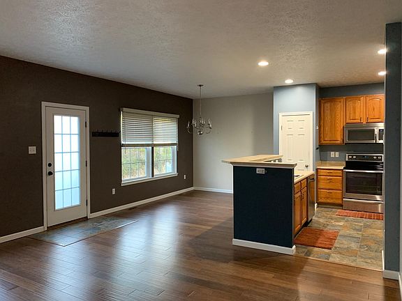 Main floor with open floor plan - living area, dining area, and kitchen. View of yard and wooded area from windows.