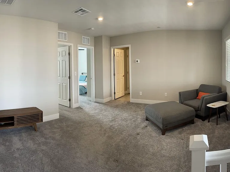 Third floor common space with access to large balcony, two guest bathrooms, and full bathroom