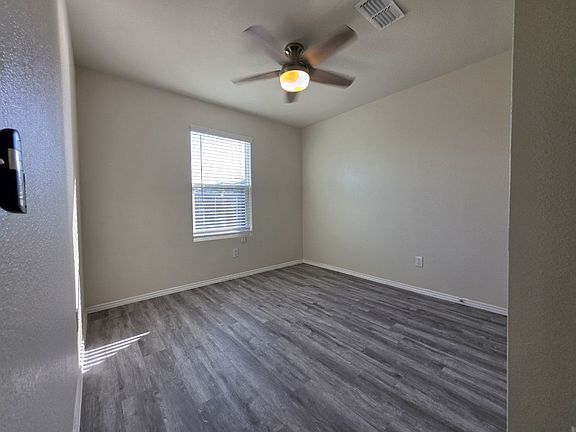 First-Floor Bedroom with Luxury Vinyl Plank Flooring and Ceiling Fan