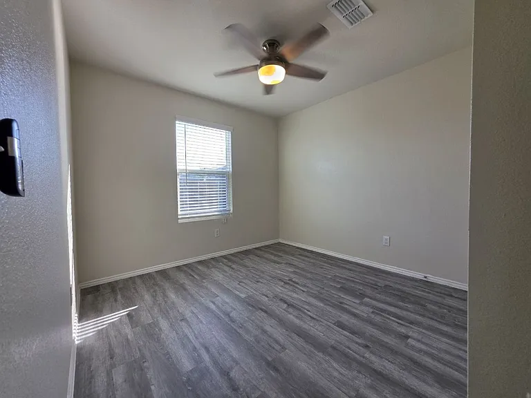 First-Floor Bedroom with Luxury Vinyl Plank Flooring and Ceiling Fan