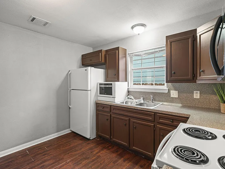 Cozy kitchen w/ all the appliances: dishwasher, microwave, fridge, stove.