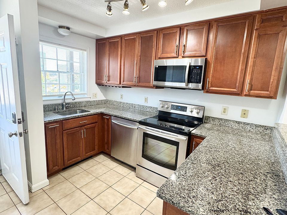 Roomy kitchen with ample cabinet space, stainless steel appliances, & granite countertops.