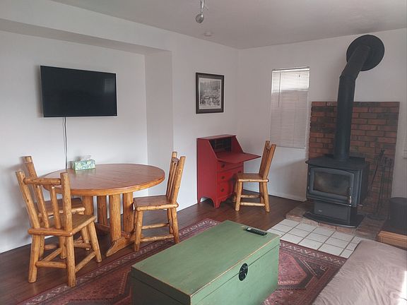 Open floor plan with eating area, work area with desk and smart tv