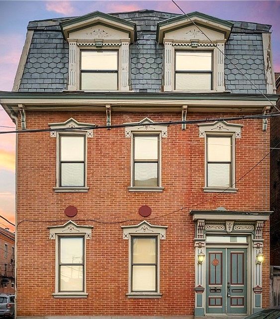 Front of the building on Bingham Street. Second floor with 3 double large double hung windows. Two windows in the master bedroom.