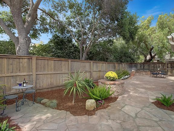 Backyard patio shaded by oaks