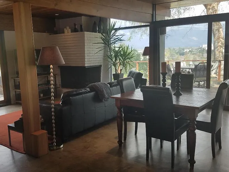 Spacious open floor plan seamlessly connects the dining and living areas, anchored by an original mid-century gas fireplace.