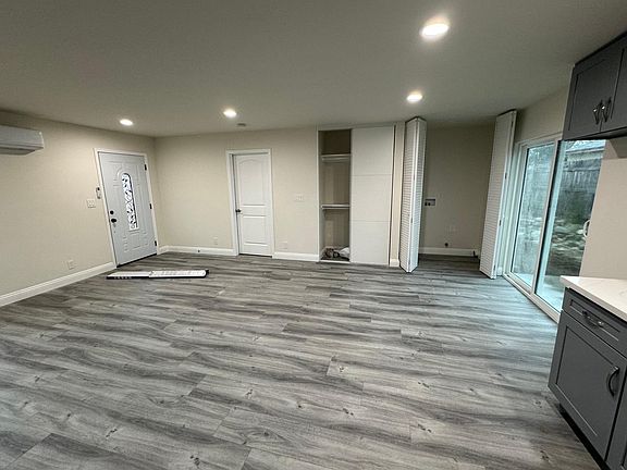 Living room space with storage closet and washer/dryer closet. Double glass back doors to private small yard (fenced off).