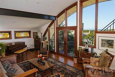 Exquisite living room with barrel ceiling and Cape Cod bay in background.