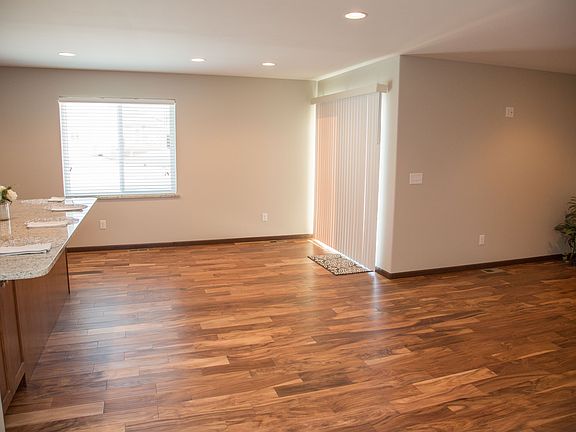 View of dining area with kitchen on the left, living room on the right.