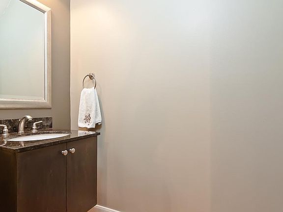 FIRST FLOOR-powder bath features Stained wood floating vanity with undermount sink, framed mirror