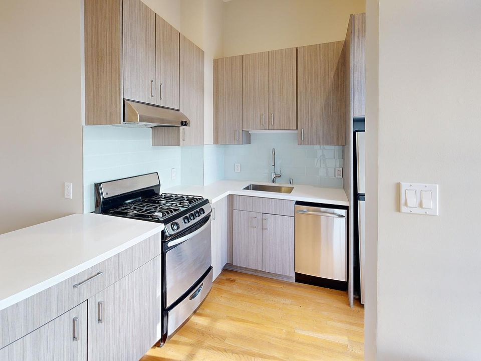 Modern kitchen with wood cabinets, stainless steel appliances, and tile backsplash. Clean, minimalist design and bright ambiance.