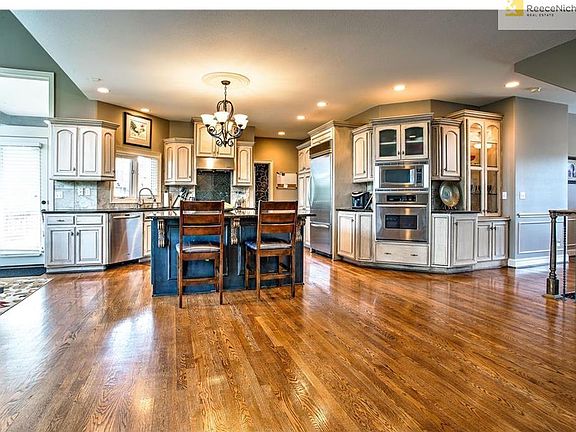 Gourmet style kitchen with custom cabinets, over sized island, built in appliances and granite count
