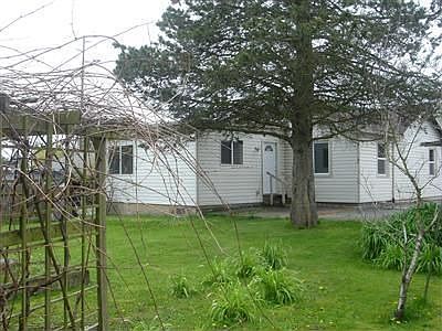 Nice partially fenced back yard with garden space and nice plants.