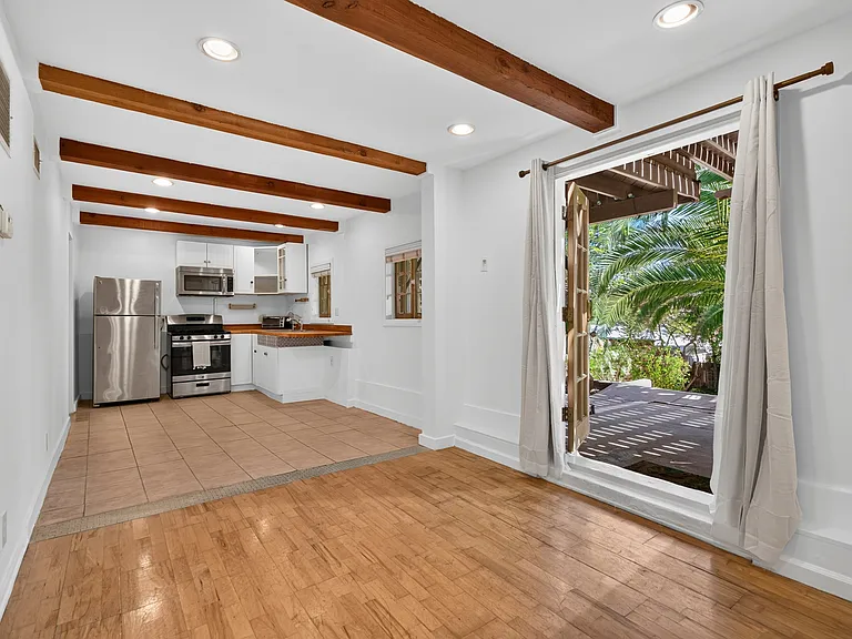 Inside studio (living area + kitchen view) - wood beams, wood floors + french doors