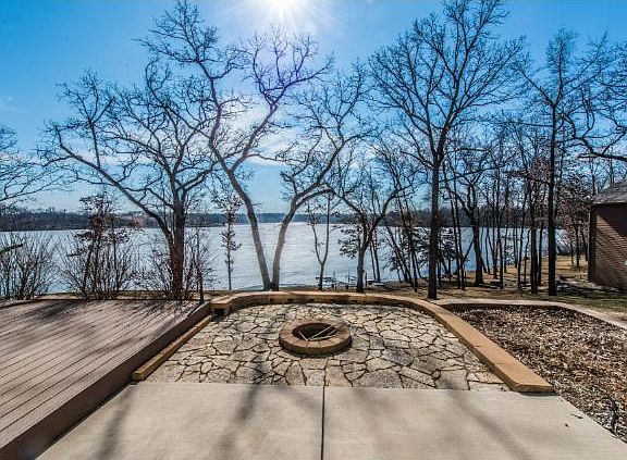 Landscaped firepit overlooking just the few level steps to the sandy lakshore