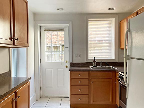 Kitchen equipped with a gas range/oven, new stainless steel refrigerator/freezer (not pictured), garbage disposal, and microwave oven. Access to the private outdoor patio.