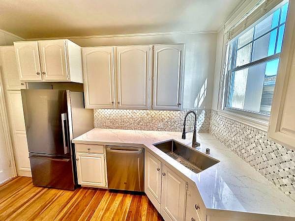 Unit #303 spacious kitchen with custom backsplash and all full size STAINLESS STEEL appliances!