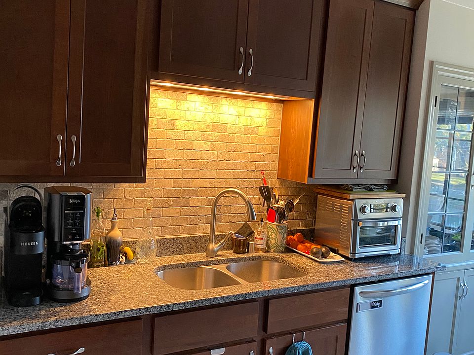Kitchen with stone backsplash and Kohler fixtures.