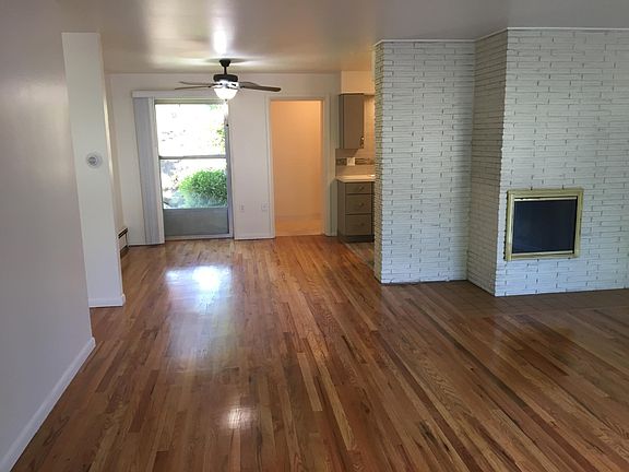 Living room from front door looking to dining, kitchen and rear door. Hey look a fireplace to keep you warm in the winter.