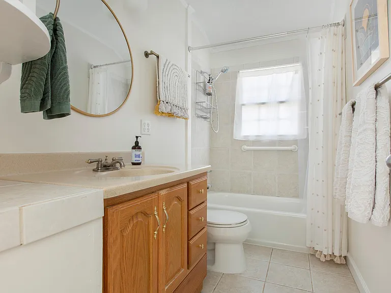 Window inside bathroom has privacy wrap as well as a privacy curtain.