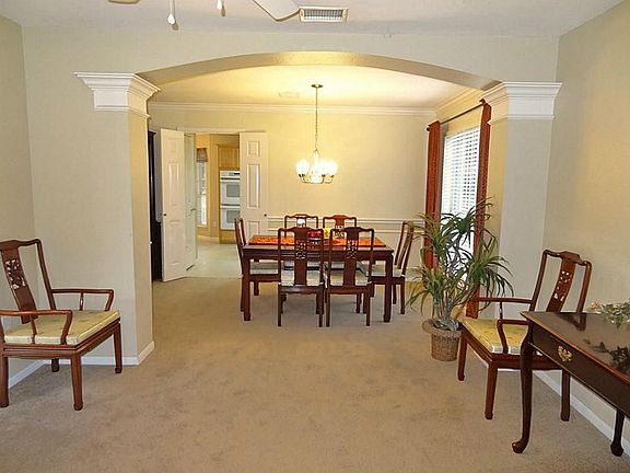 Formal living room flows into the formal dining room.  Notice the arched opening and decorative double crown molding on the columns, crown molding & chair-rail molding in the dining room.