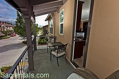 Kitchen view balcony and covered sitting area with chairs an