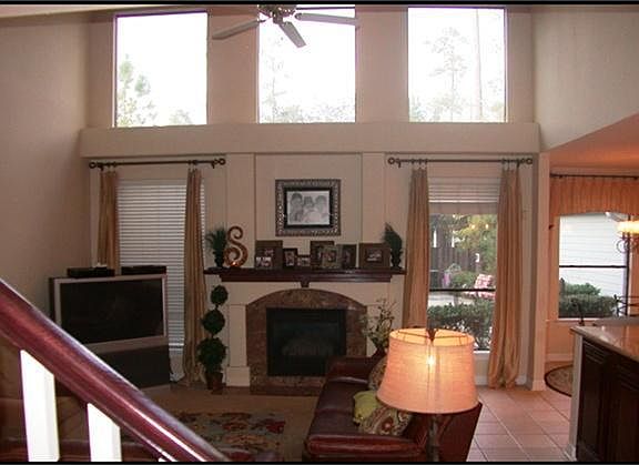 TWO STORY FAMILY ROOM  WITH FIREPLACE AND TILE FLOORS.