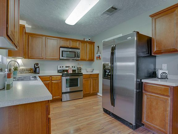 Very functional kitchen with plenty of cabinet space and stainless steel appliances. Laundry is around the corner from the refrigerator.