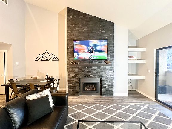 Living room with large sofa-bed sectional and storage chaise lounge, 65 in LED TV, fireplace, balcony with grill and sweeping views of Beaver Creek mountain