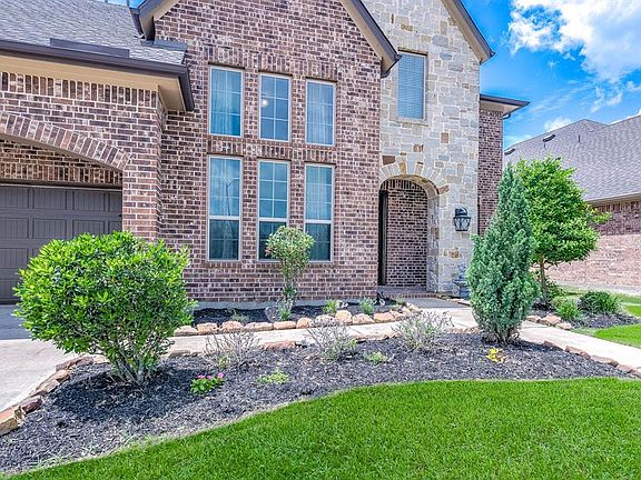 Approaching the front door you will see the beautiful brick and stone elevation, covered front porch, and lovely landscaping!