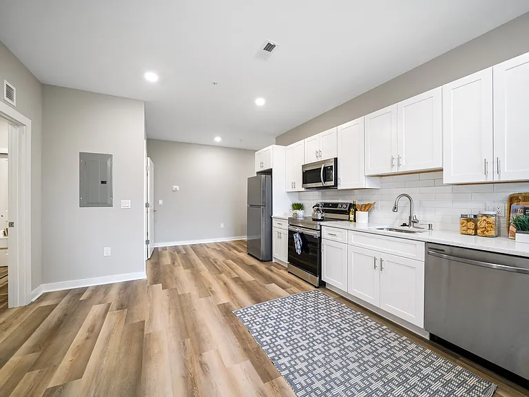 Spacious kitchen with white cabinets and stainless steel appliances