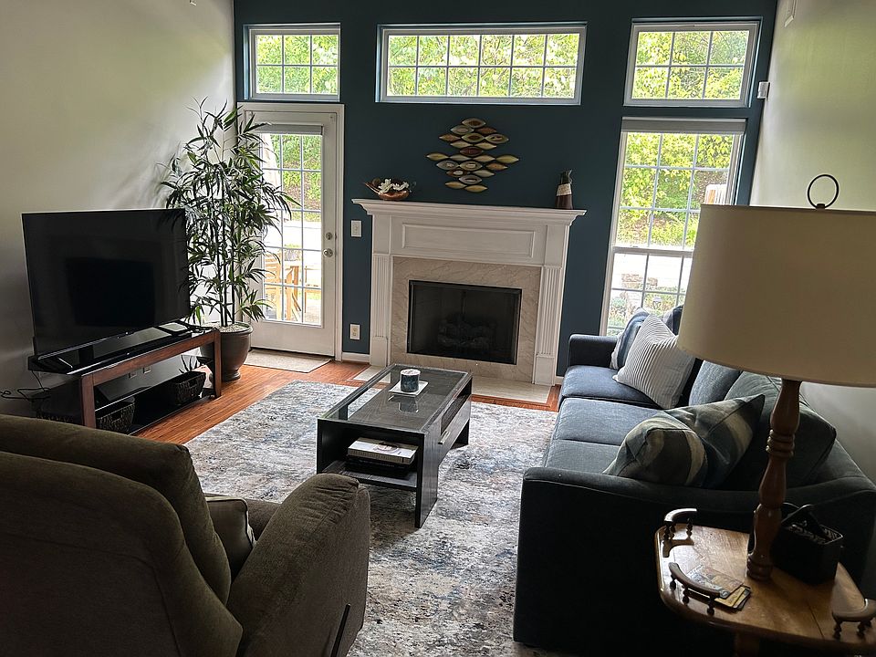 Living room with gas fireplace, brand new paint, rug, 65" TV & very comfortable Haverty's furniture including rocking recliner chair.