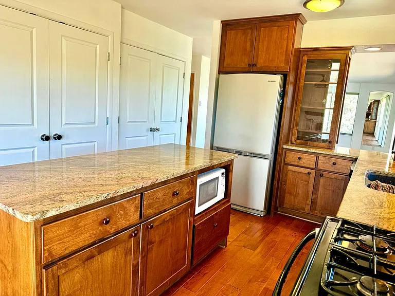 Lots of custom cabinets, undercounter hidden microwave, gas stove, double oven, large pantry