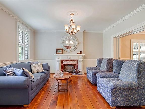 Formal living room with wood floors, plantation shutters