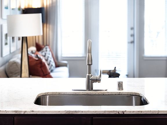 Kitchen with oak cabinetry, granite countertops, tile backsplash, and stainless steel appliances