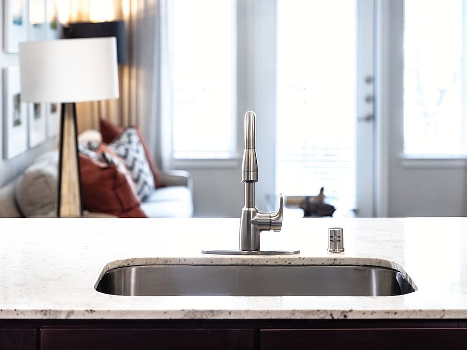 Kitchen with oak cabinetry, granite countertops, tile backsplash, and stainless steel appliances