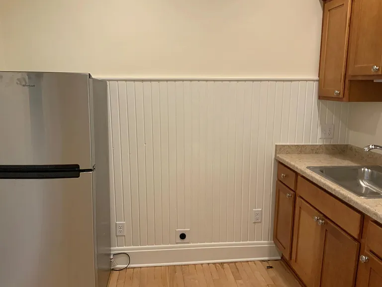 Kitchen view between refrigerator and cabinets. Cozy space big enough for table and chairs.