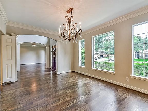 Formal Dining room off of entry to the left features elegant chandelier and gleaming hardwood floors and leads to the kitchen through swinging double doors.